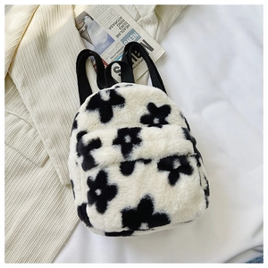 Détail du sac à dos en peluche à motif floral noir et blanc avec bretelles tissées