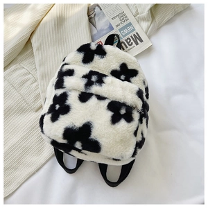 Gros plan du sac à dos en peluche douce aux motifs floraux noirs et blancs audacieux