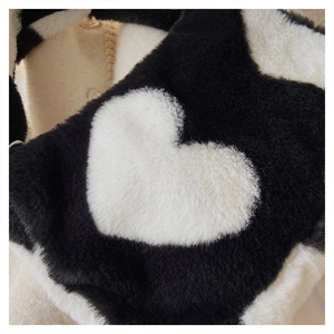 Gros plan sur la texture en fausse fourrure douce avec motif cœur imprimé vache