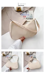 Detailed macro view of a light khaki nylon crescent underarm bag with smooth zipper texture