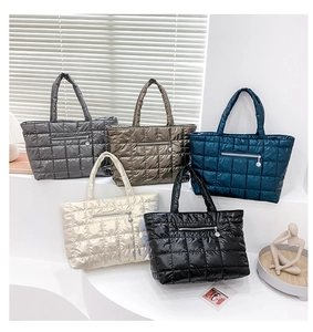 Dettaglio di borse tote trapuntate in cinque colori metallizzati con tasche a cerniera