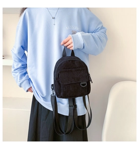 Detailaufnahme eines schwarzen Mini-Rucksacks aus Cord mit Textur und D-Ring-Schnalle