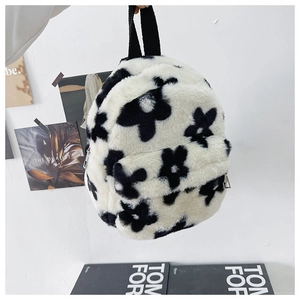 Détail d'un sac à dos en peluche blanche avec motifs floraux noirs et fermeture argent