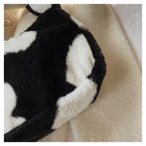 Gros plan sur la texture douce en fausse fourrure imprimé vache noire et blanche du sac