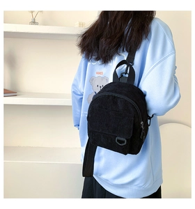 Detailansicht der schwarzen Cord-Minirucksack-Textur und Vordertasche mit D-Ring-Schnalle