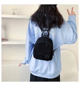 Detailansicht des schwarzen Mini-Rucksacks aus Cord mit feiner Textur und Vintage-Stil