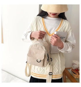 Detail eines beigen Cord-Minirucksacks mit Vordertasche und verstellbaren Trägern