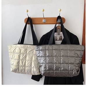 Detail of quilted tote bags in metallic gold and silver with padded down fabric