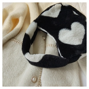 Vue détaillée du sac à main en peluche avec motif vache et cœurs noirs sur fond blanc