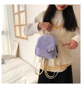 Detail eines hellvioletten Cord-Minirucksacks mit weicher Textur und Vordertasche