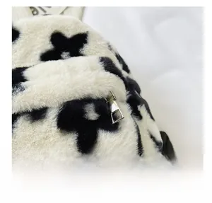 Détail du sac à dos en peluche à fleurs noir et blanc avec fermeture éclair en métal argenté