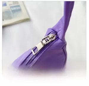 Detail view of the durable silver metal zipper and purple nylon fabric on the crossbody bag