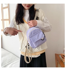 Detailansicht des lila Cord-Minirucksacks mit vorderer Klappentasche und Textilgurt