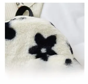 Gros plan sur la texture en peluche à fleurs noires et blanches du sac à dos femme