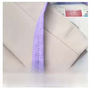 Detail of wear-resistant beige nylon shoulder strap with purple trim and clean stitching