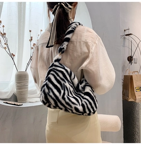 Flauschige Hobo-Tasche mit Kuhmuster an der Schulter mit weicher Plüschstruktur in Schwarz-Weiß