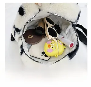 Vue macro montrant la grande capacité du sac à dos en peluche à fleurs noir et blanc