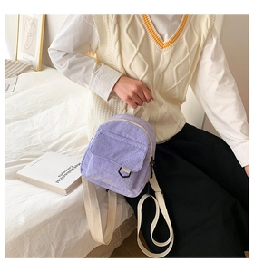 Detailansicht lila Cord Rucksack mit vorderer Pattentasche und cremefarbenem Gurtband