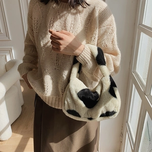 Sac seau en fausse fourrure à motif vache assorti à un pull en maille hivernal