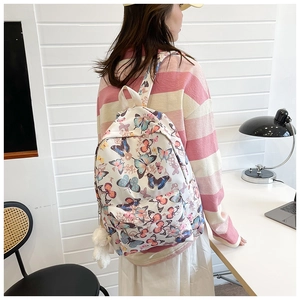 Detail of white butterfly backpack with zipper pocket and cute white plush bear pendant