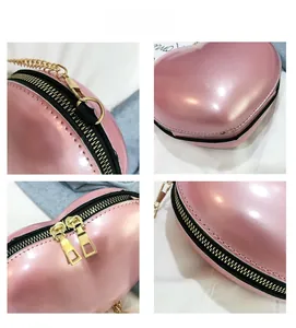 Close-up of pink heart-shaped bag with gold metal zippers and premium stitching details