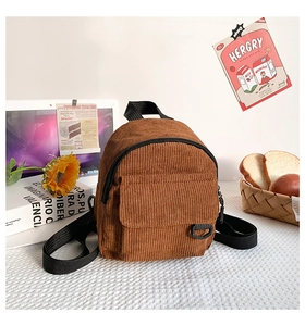 Detailansicht eines braunen Cord-Mini-Rucksacks mit vertikaler Textur und Klapptasche