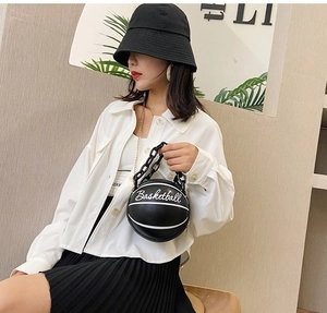 Detailed view of a unique black basketball-shaped handbag with acrylic chain strap