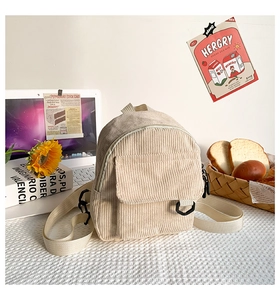 Detailansicht des cremefarbenen Cord-Minirucksacks mit Klapptasche und Trägern