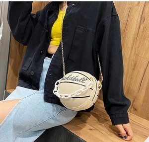 Detail view of white basketball shaped crossbody bag with gold chain and acrylic handle