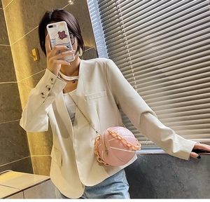 Detail view of pink basketball-shaped crossbody bag with decorative chain and metal strap
