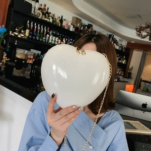 Chic white heart-shaped chain bag in glossy patent leather with a golden zipper strap