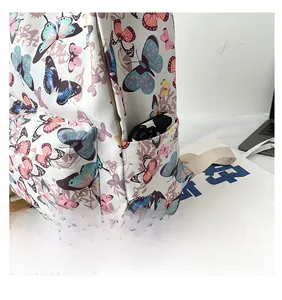 Close-up of side pocket on white butterfly backpack showing a smartphone storage detail