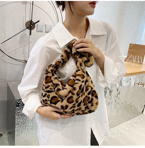 Detail of soft leopard print faux fur handbag held by a model with a gold ring clasp