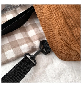 Detail der braunen Cordtasche mit schwarzem Nylongurt und Karabinerhaken aus Plastik