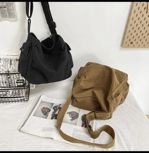Detail view of washed canvas messenger bags featuring adjustable straps and side flap pockets
