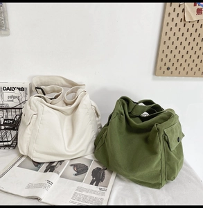 Detail of canvas messenger bags in beige and olive green with adjustable buckle straps