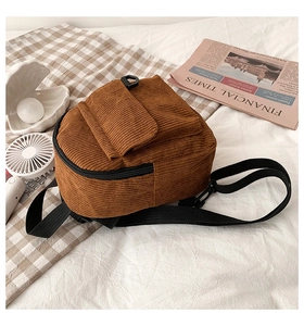 Detailansicht eines braunen Cord-Rucksacks mit vorderer Klappentasche und schwarzen Trägern
