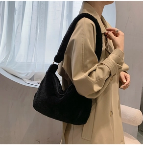 Close-up of black faux fur shoulder bag featuring streamlined half-moon shape and metal ring