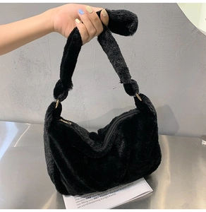 Detailaufnahme des weichen schwarzen Plüschmaterials und Griffs dieser flauschigen Damen Tasche
