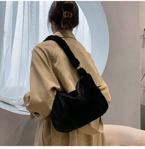 Detail of soft black plush shoulder bag showing fluffy texture and integrated wide strap