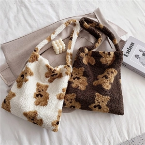 Detailed view of plush teddy bear tote bags in white and brown fleece textures