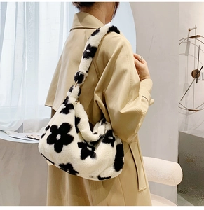 Close-up of plush faux fur shoulder bag featuring black floral patterns and soft texture