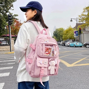 Pink Japanese style student backpack with multiple pockets and cute decorative pins