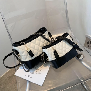 Detailed comparison of black and white quilted hobo bags in two sizes on transparent chair