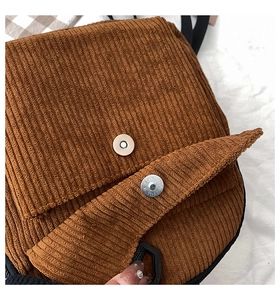 Detailansicht der braunen Cordtasche mit Magnetverschluss und silbernen Metallteilen