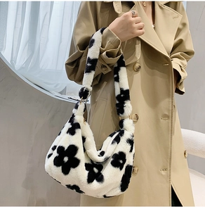 Close-up of plush cow print shoulder bag with black and white flower pattern texture