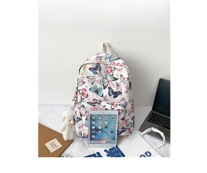 White butterfly backpack size comparison with a laptop and tablet for capacity display