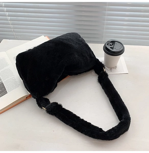 Detail der weichen schwarzen Plüsch-Schultertasche auf einem minimalistischen Tisch
