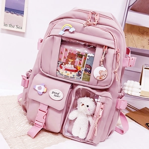 Detail view of pink student backpack with transparent pockets and decorative badges