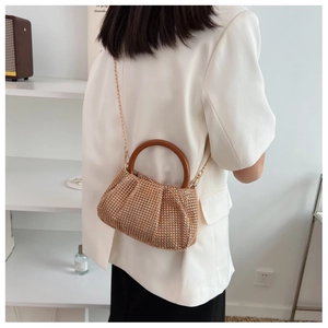 Close-up of champagne gold rhinestone bag with wooden ring handle and metal chain